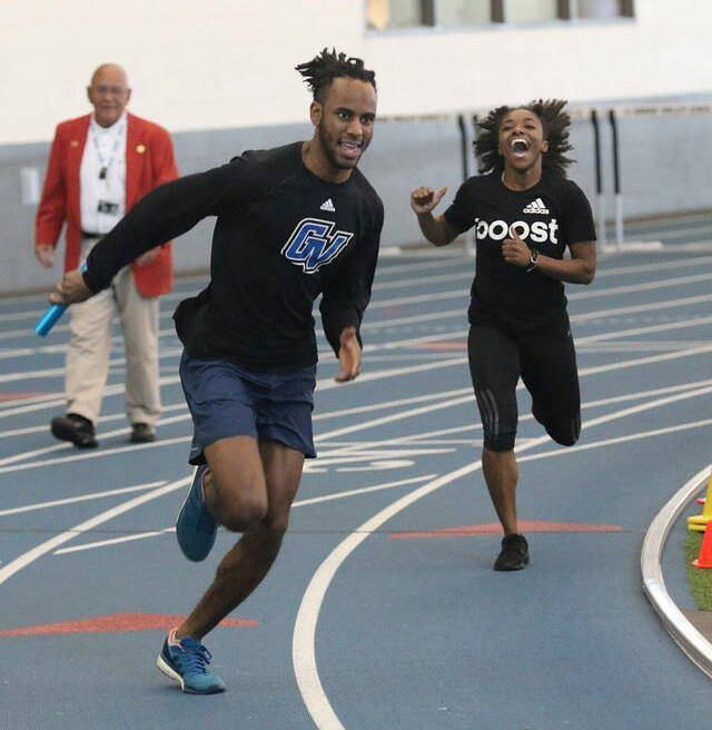 A male and female african-american running at a track meet